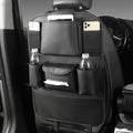 Faux leather car seat back storage organiser bag in black, shown hanging behind a car headrest.