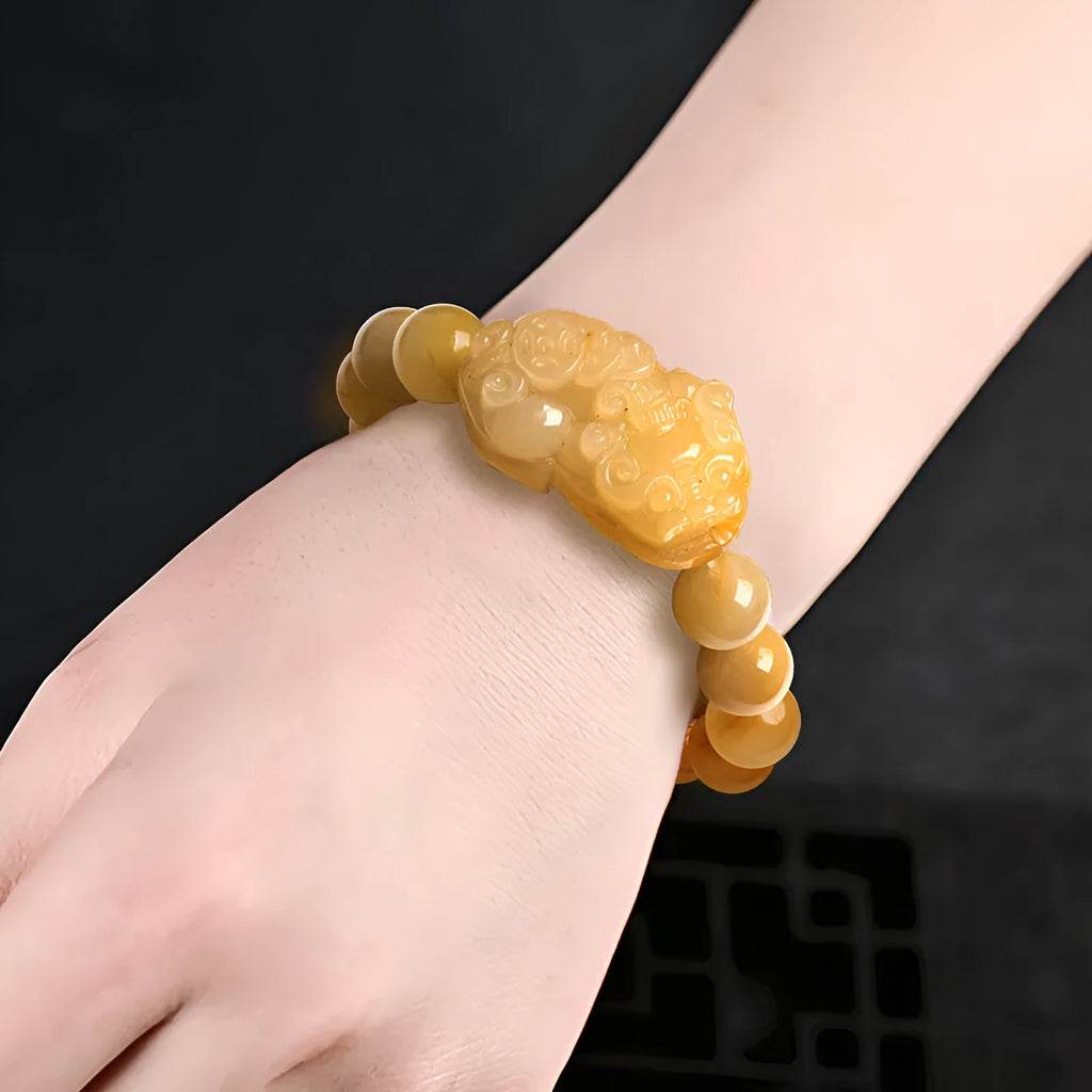 Golden thread jade bracelet with carved money motif showing detailed surface texture and jade beads