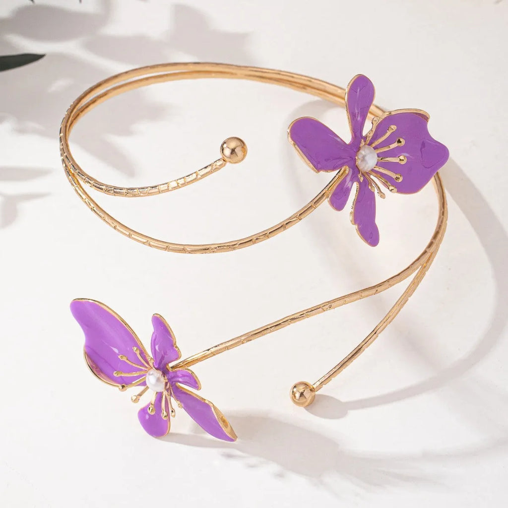 Pink and purple adjustable alloy hollow pattern armband on a wrist.