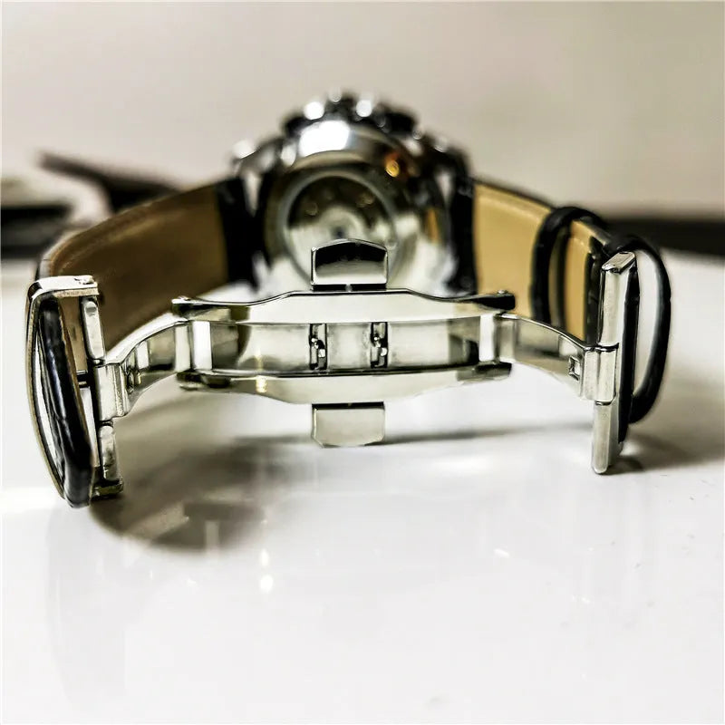 Men's automatic mechanical watch on wrist showing silver metal case and black dial.