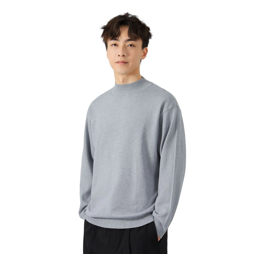 A man wearing a loose-fitting solid colour long sleeve casual pullover sweater.