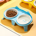 Blue ceramic cat food and water bowls on a white elevated plastic stand with hook design.