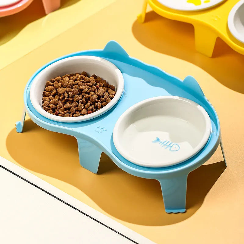 Blue ceramic cat food and water bowls on a white elevated plastic stand with hook design.