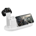 White three-in-one headphone charging stand dock on a desk with a USB cable.