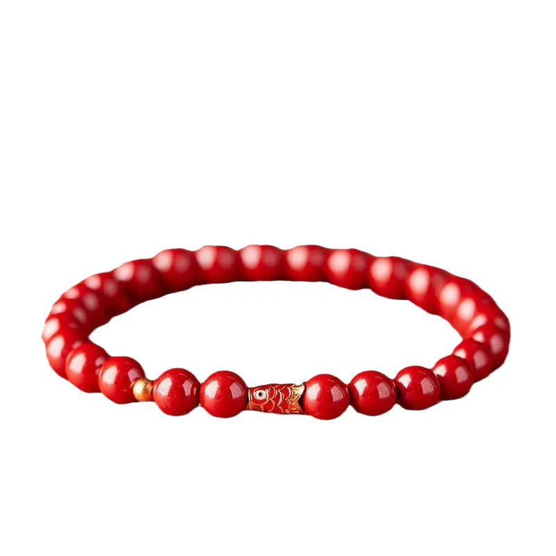 Natural cinnabar koi bracelet with golden balls in national style, showing sand grain texture