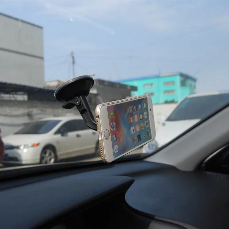 Black magnetic car phone holder with 360-degree rotating bracket mounted on dashboard