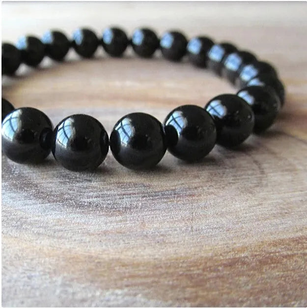 Geometric black agate bead bracelet with elastic cord, showing 8mm bead size detail.