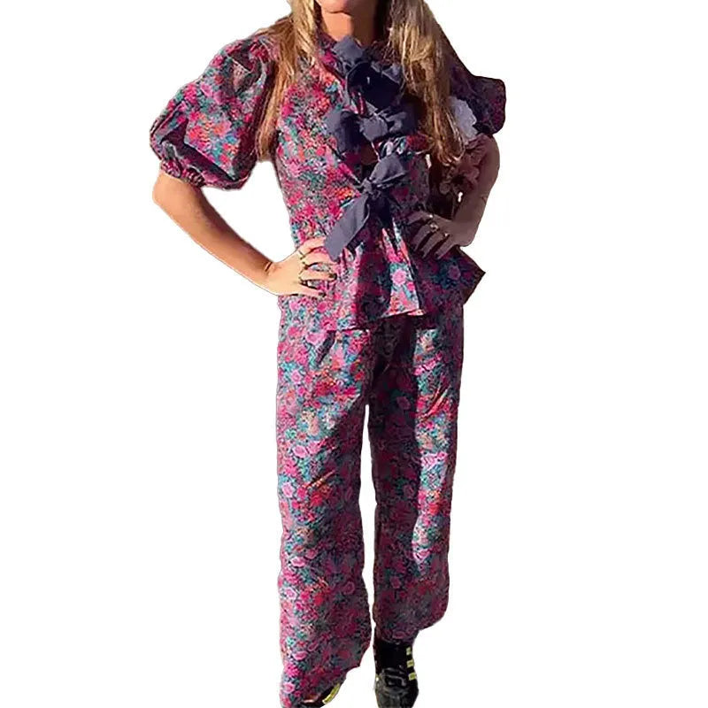 Women's floral printed trousers suit with tie-neck puff sleeve top and matching trousers in polyester fabric