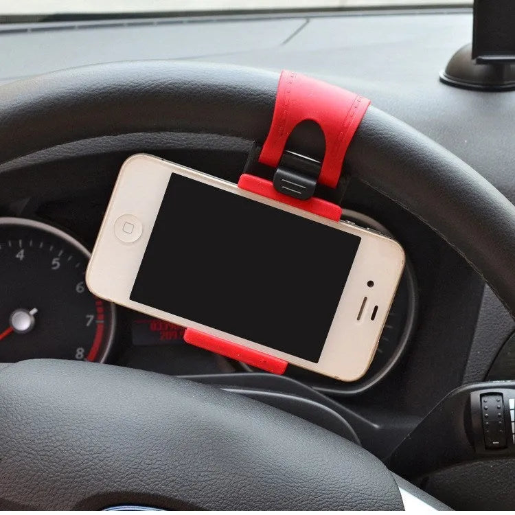 Black universal steering wheel phone holder clip mounted on a car steering wheel holding a smartphone.