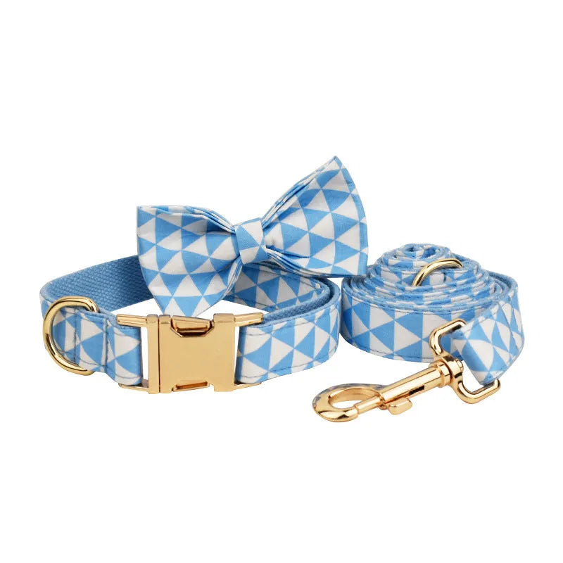 Blue cloth dog vest harness set with matching collar, leash, and decorative bow tie on a small dog