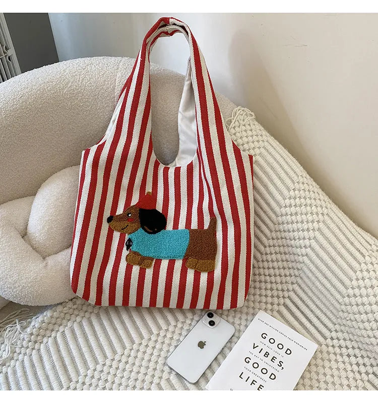 Soft canvas shoulder bag with red stripes and cartoon embroidery of a puppy wearing a red hat, square vertical shape, double shoulder straps