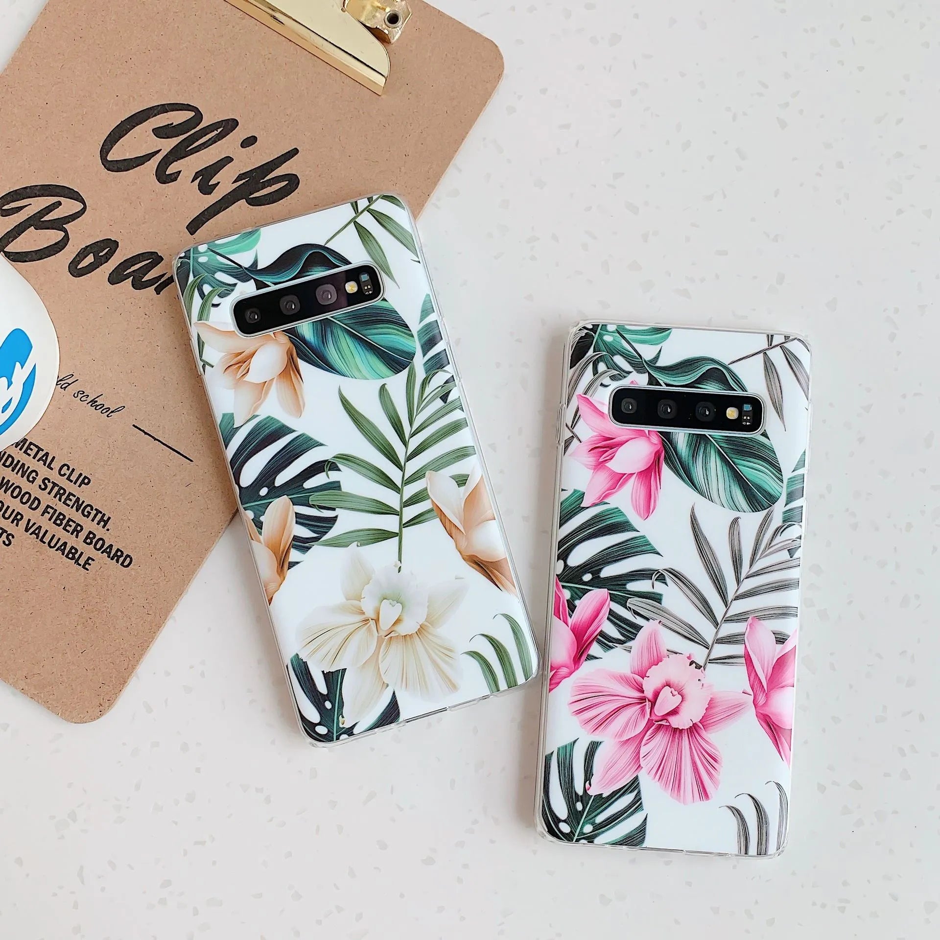 Samsung floral TPU phone case in safflower colour with green leaf design on a table.