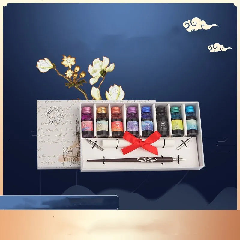 Wooden gift box open to show a dip pen, bottles of coloured ink, spare nibs, and a standing pen holder.