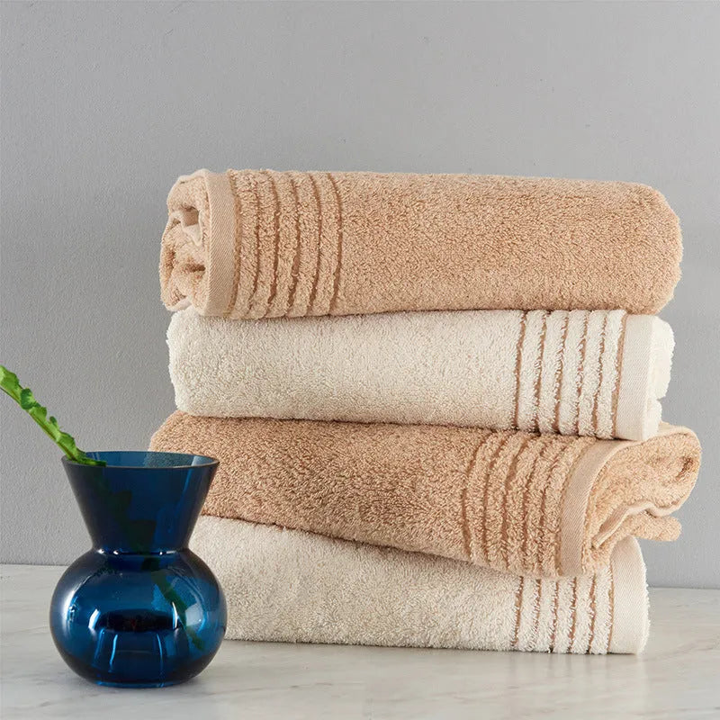 Beige and brown cotton bath towel set showing large bath towel, hand towel, and small face cloth.