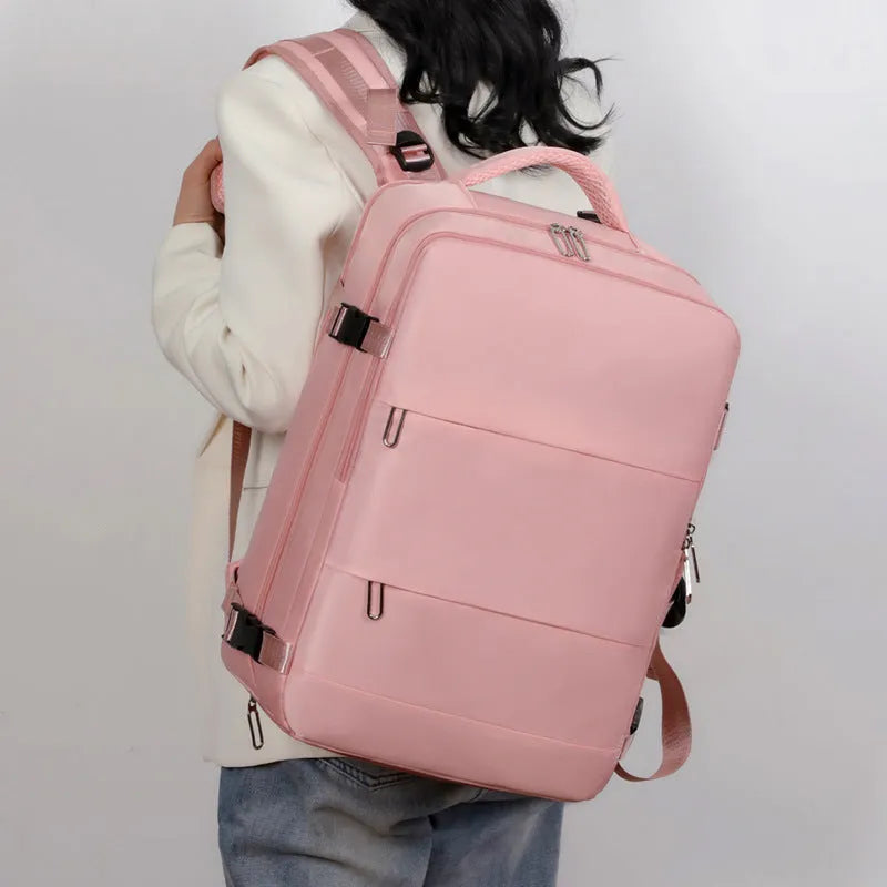 Large purple women's travel backpack with multiple pockets and air pillow belt on a grey background