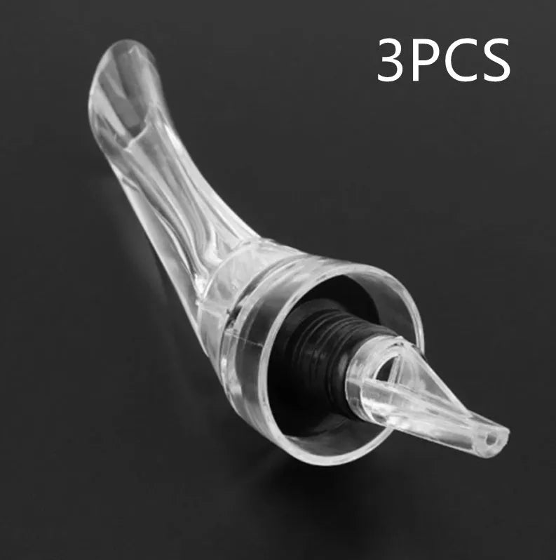 Clear acrylic wine aerator with stainless steel filter, shown next to a wine glass.