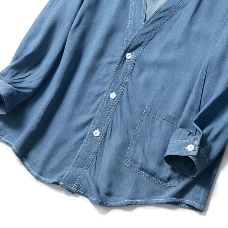 Men's dark blue denim coat with three-quarter sleeves and V-neck collar showing front pocket detail