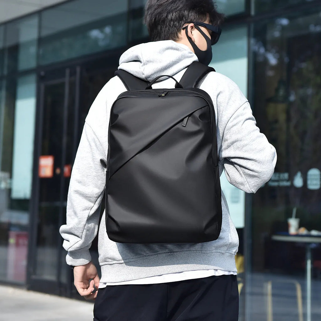 Large black waterproof PU leather backpack for men with simple design and sewing thread details.