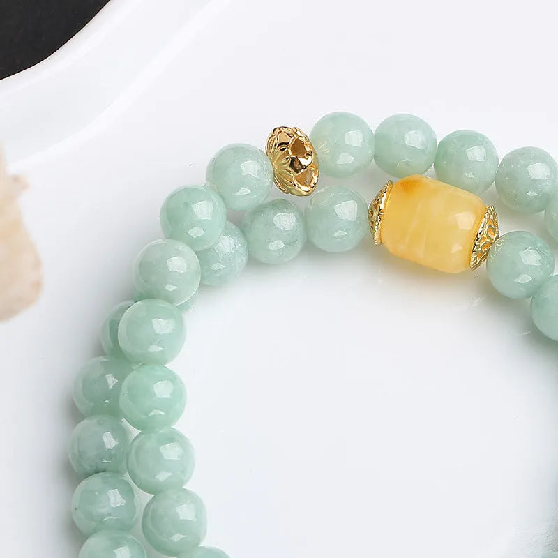 Close-up of a double-layer women's bracelet with green jade round beads and brown beeswax barrel beads in a geometric design.