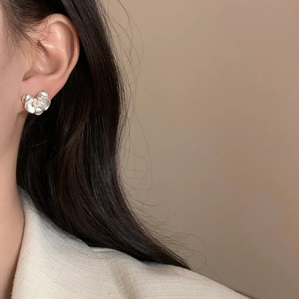Retro style flower earrings for women in gold or silver finish with petal detailing