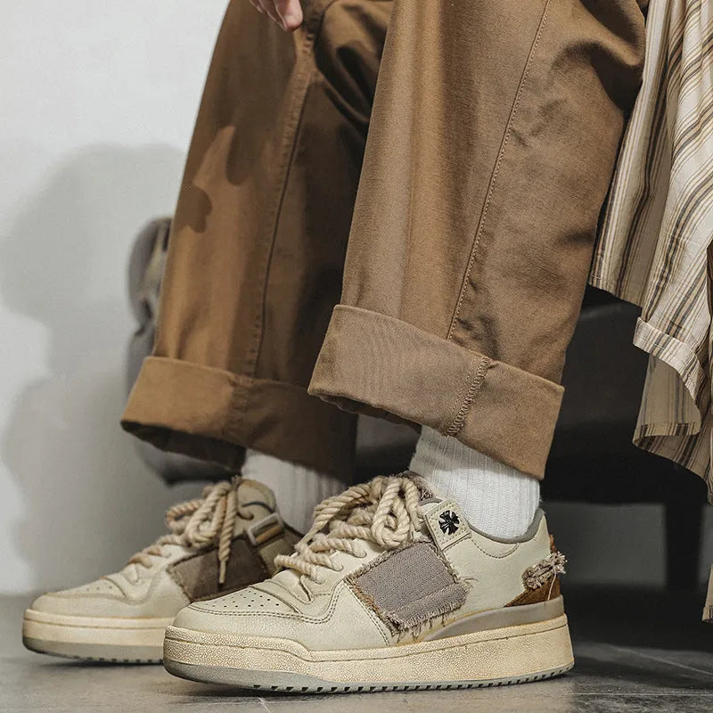 Beige low-top vintage skate shoes with round toe and front lace-up closure on a solid background.