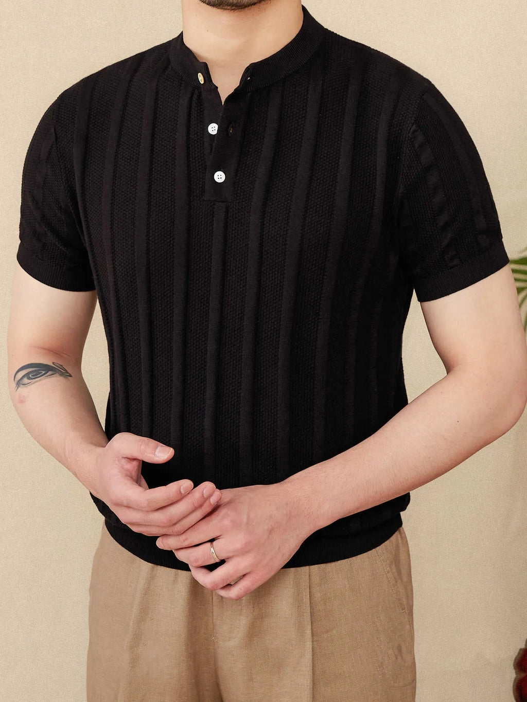Men's creamy-white Henry collar cotton T-shirt with sunken stripe design on thin fabric.