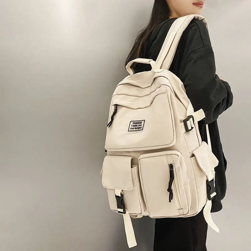 Black and white nylon student backpack with front pockets and laptop compartment.
