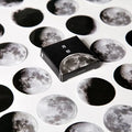 Black moon phase, planet, and calendar design stickers on a sheet, 45 pieces total.