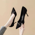 Gold and black women's stiletto pointed toe high heels on a white background.