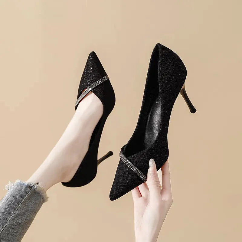 Gold and black women's stiletto pointed toe high heels on a white background.