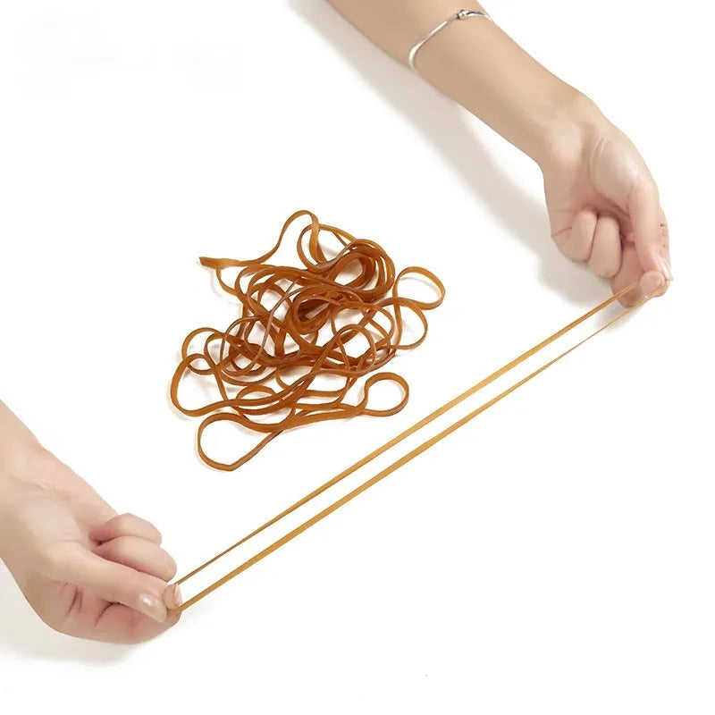 A pile of natural-coloured, round rubber rings next to a 500g bag.