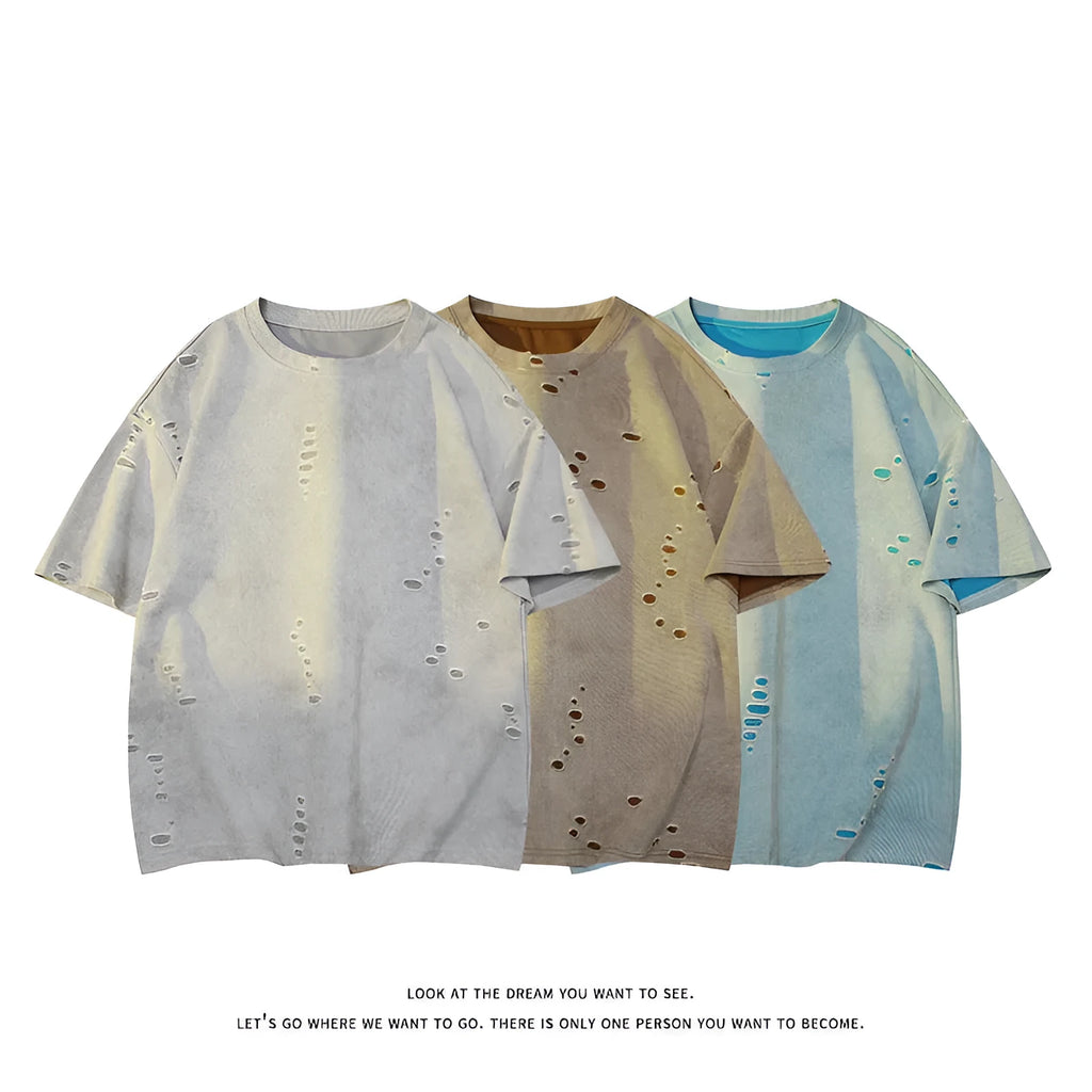 Men's blue loose-fit distressed short-sleeve t-shirt with ripped fabric detailing on a casual backdrop.