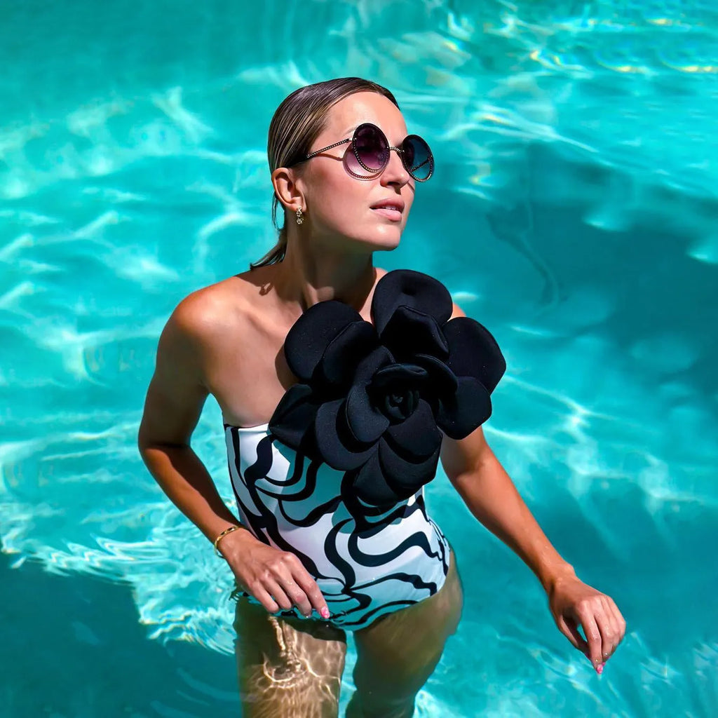 Women's solid colour one-piece swimsuit with three-dimensional flower design for swimming.