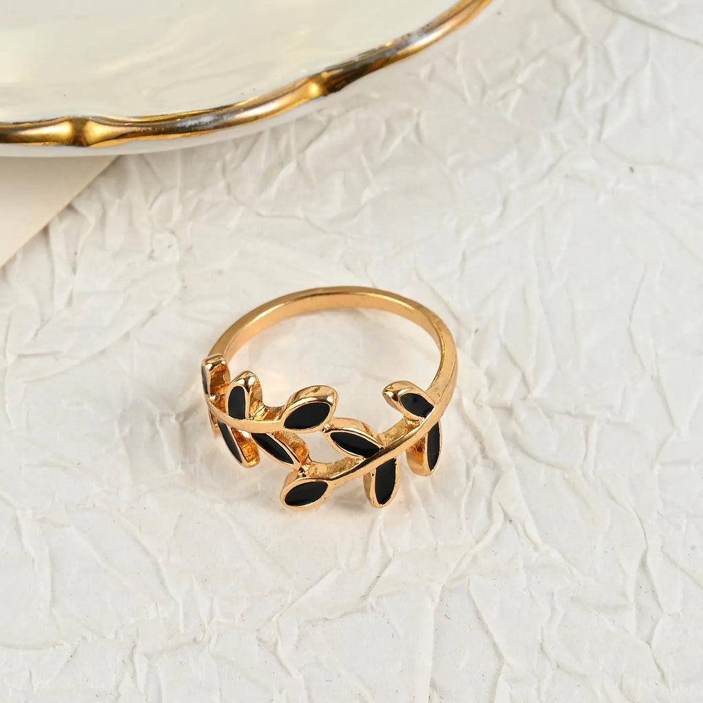 Gold geometric leaf acrylic ring for women on an index finger.