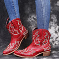 Women's blue embroidered cowboy boots with a low wedge heel and pointed toe.