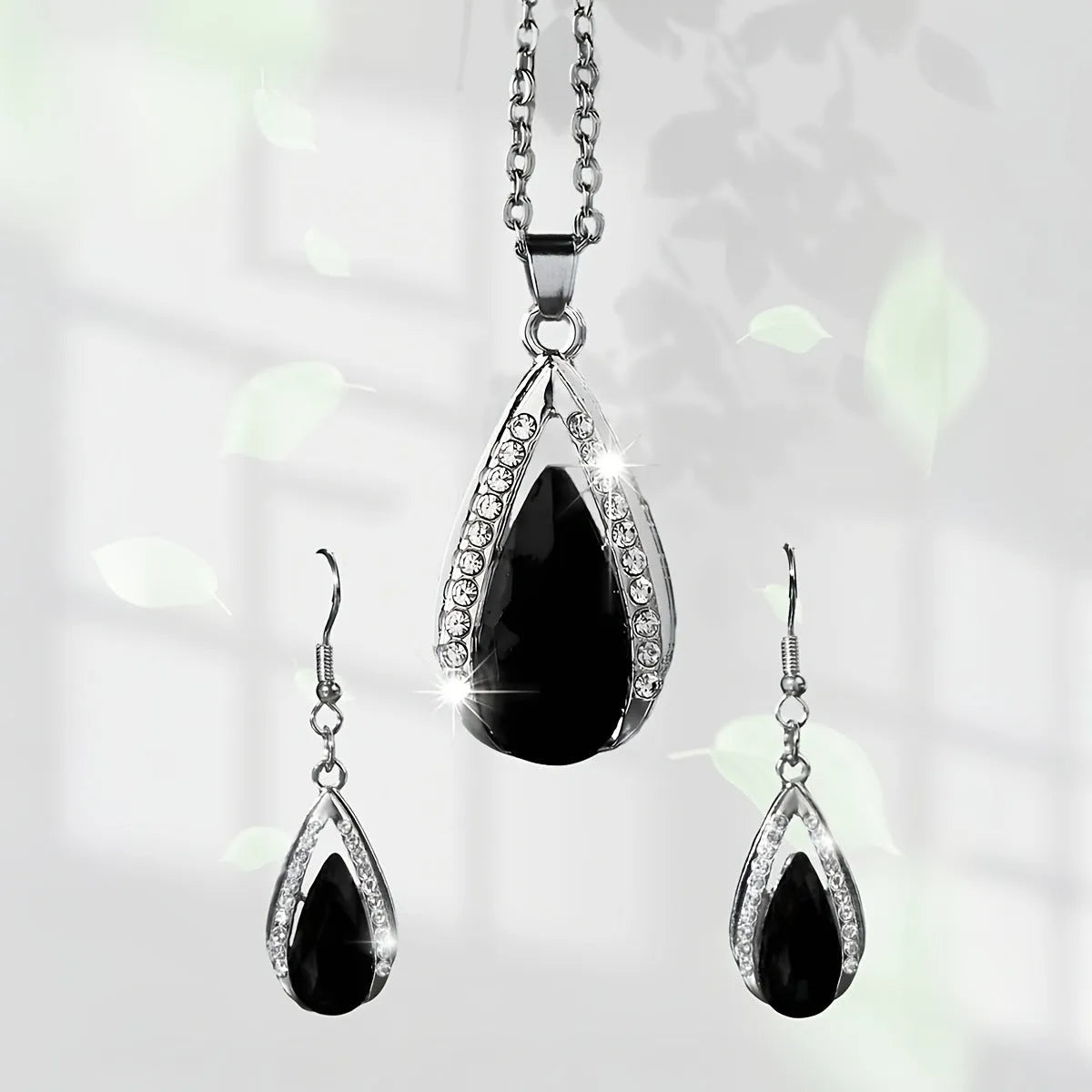 Alloy teardrop pendant necklace and matching earrings set in black or red finish.