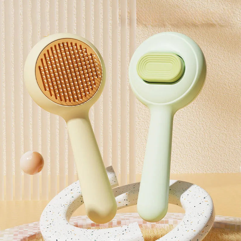 Green cat grooming brush with stainless steel teeth and a removable hair collection tray on a white background.