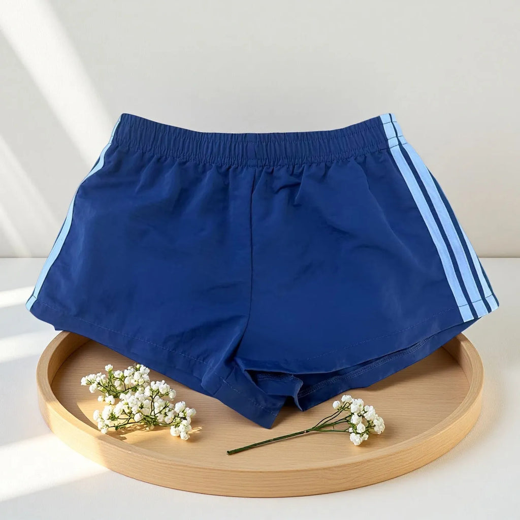 Men's navy blue high-waist nylon sports shorts laid flat, showing casual style and micro-elastic fabric.