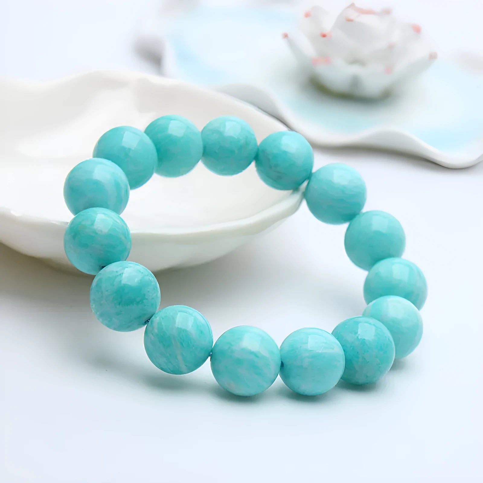 A single green amazonite bead bracelet on an elastic cord, shown in a natural setting.