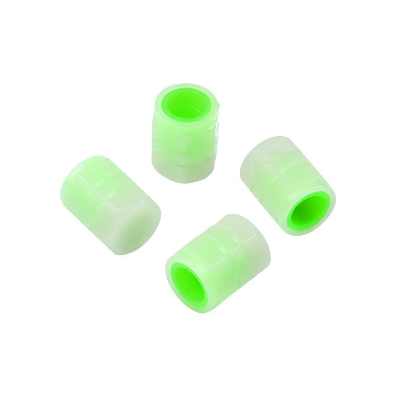 Black rubber luminous car tyre valve cap with glow-in-the-dark tip, shown next to a coin for scale.