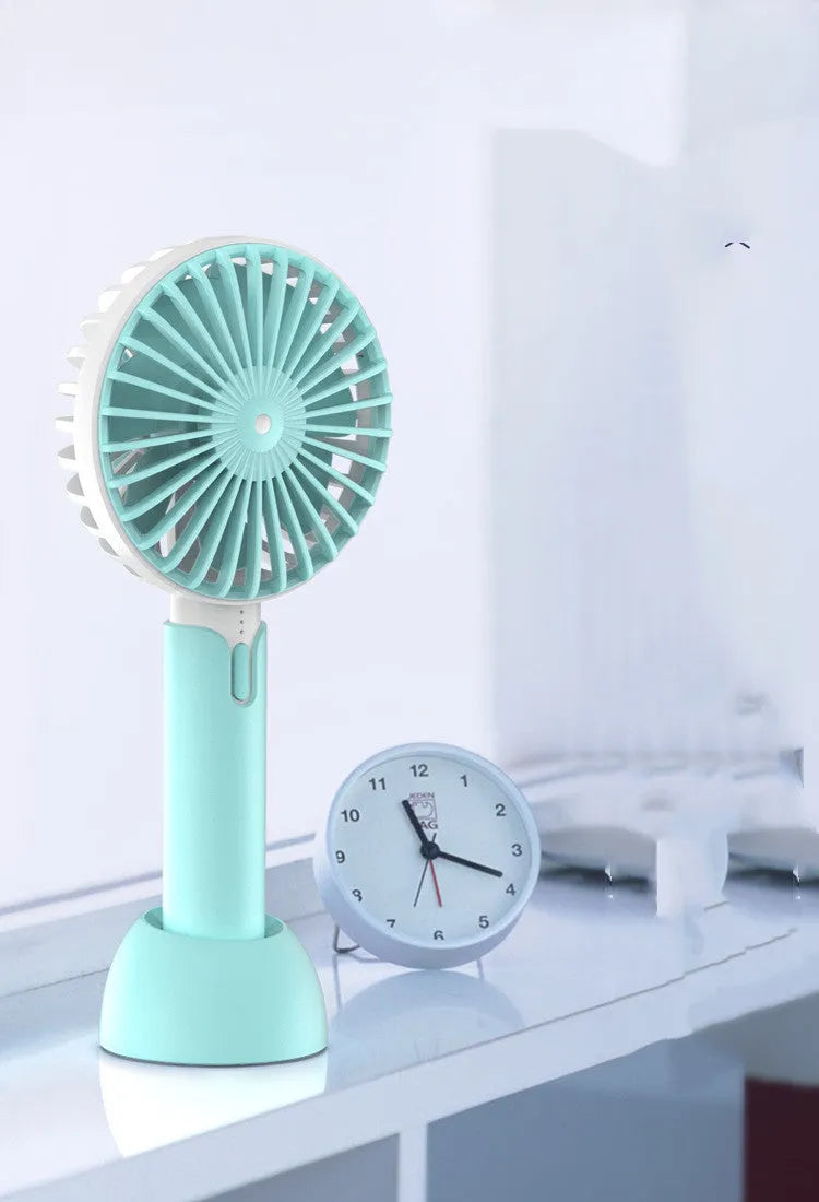 Blue mini silent USB handheld fan with oscillation, shown on a desktop.