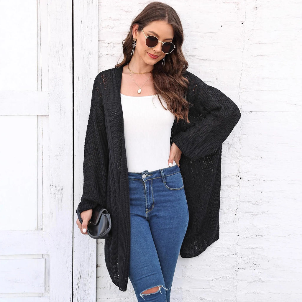 Women's loose brown acrylic sweater coat hanging, showing solid colour and knit texture.