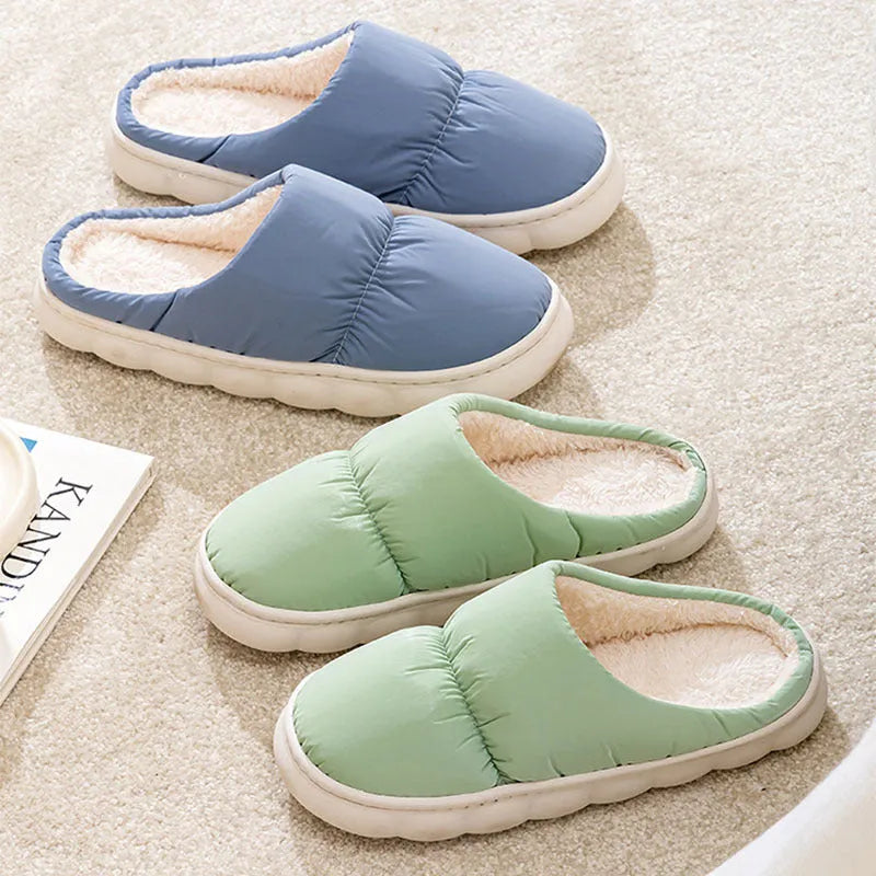A pair of thick-soled house slippers with an artificial leather upper and plush lining, shown in a choice of colours.