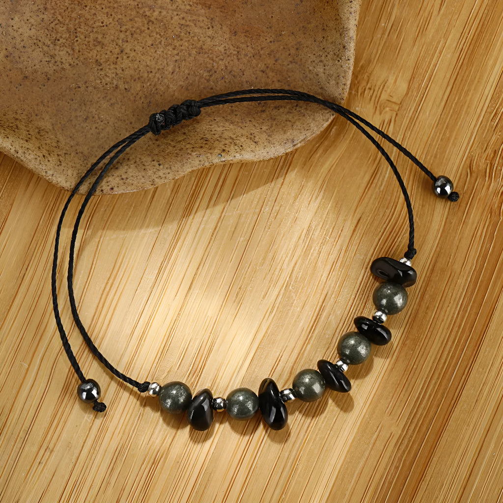 Close-up of a black garnet stone beaded bracelet with geometric design and moon charm.