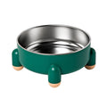 Green stainless steel pet bowl with non-slip base and high foot on a kitchen floor.