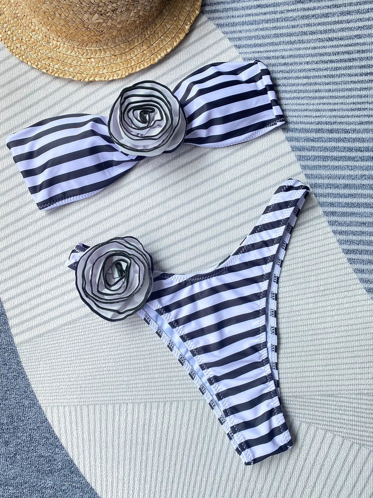 Bikini swimsuit with tube top design and three-dimensional flower detailing in striped pattern