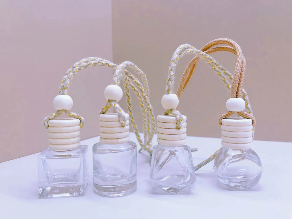 Glass car perfume pendant air freshener in cylinder, diamond, flat drum, and square shapes.