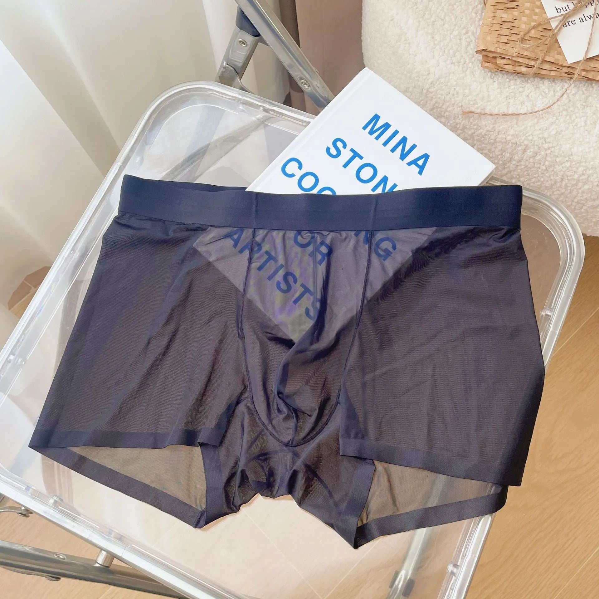 Men's thin grey nylon boxer shorts laid flat, showing seamless mid-waist design.