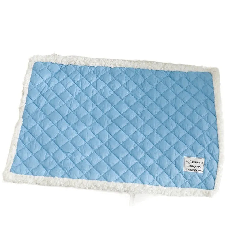 Quilted blue terry cloth pet blanket for cats on a white background, showing size scale.