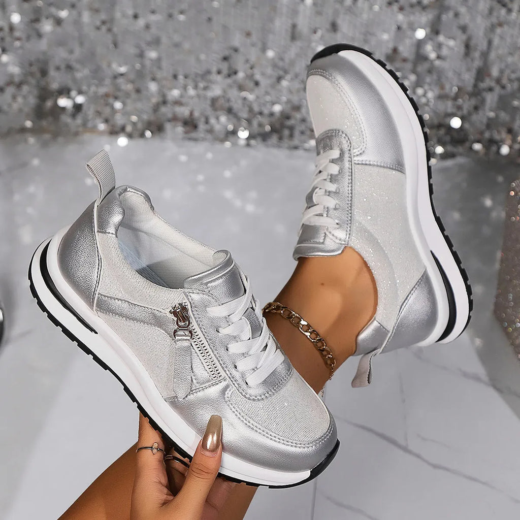 Gold women's lace-up pumps with round toe and flat rubber sole on a white background.